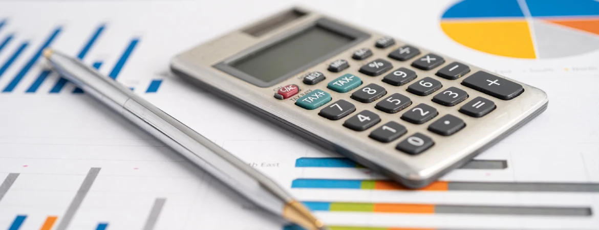 Kalkulator i&nbsp;długopis na&nbsp;tle kolorowego raportu